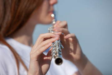 Girl playing the flute in the garden.