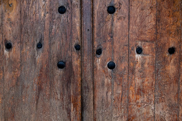 antique wooden door with black rivets. Rusty nails in an old wooden door. background - vintage tree.