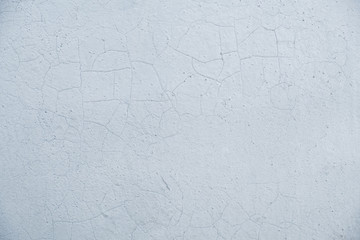 Stone white wall with shallow cracks.  Background in the form of an old bleached wall with cracks.