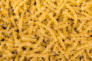 A lot of pasta curls spiral poured in bulk.  spiral macaroni close up