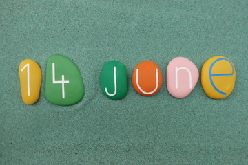 14 June, calendar date composed with multi colored stones over green sand