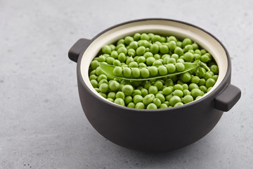 Fresh green peas in big ceramic pot