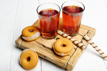 Two cups of hot tea with delicious cookies on  wooden table.