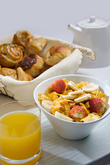 breakfast with cereals with fruits, juice and pastries.