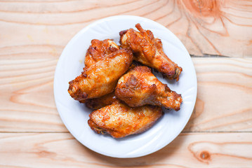 Baked chicken wing bbq grill on plate wood table background - hot and spicy chicken and sauce