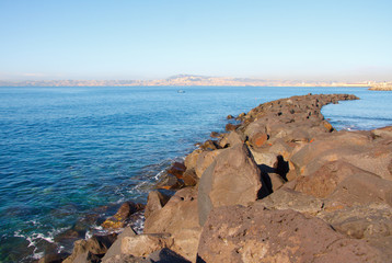 Fototapeta premium Beautiful narrow bay in a rocky sea shore against the blue sky