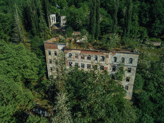 Ruined overgrown school in ghost mining town Akarmara, consequences of war in Abkhazia, aerial view...