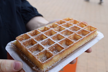 Closeup of a Belgian waffle - Brussels waffle with powdered sugar on top
