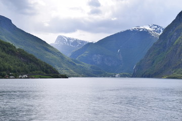 Norwegian fjord view from a Scandinavian cruise ship. Clam water with mountains and glaciers in the background