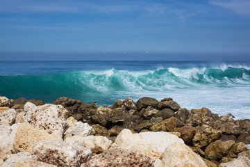 Fototapeta na wymiar sea view. blue ocean, big waves, black and white stones, high tide