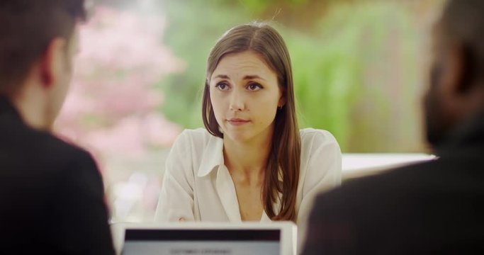 4K Young businesswoman being reprimanded by bosses in disciplinary meeting. Slow motion.