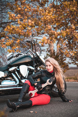 Plakat Beautiful biker woman posing with motorcycle outdoors.