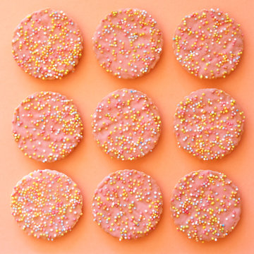 Pattern of pink biscuits with hundreds and thousands.