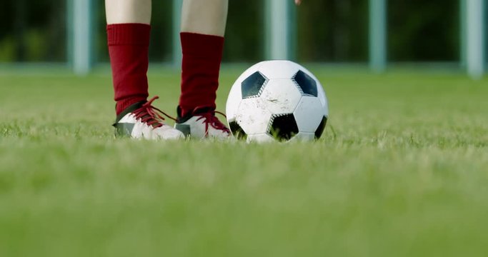 CU of young Caucasian teenager girl soccer football performing penalty shot, kicking a ball. 4K UHD 60 FPS SLOW MOTION