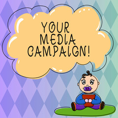 Text sign showing Your Media Campaign. Conceptual photo marketing effort to reinforce assist with business goal Baby Sitting on Rug with Pacifier Book and Blank Color Cloud Speech Bubble