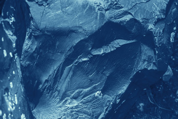 Vintage blue background. Rough painted wall of sapphire color. Imperfect plane of blue colored. Uneven old decorative toned backdrop of cyan tint. Texture of sapphirine hue. Ornamental stony surface.