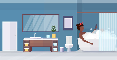 woman lying in bathtub using smartphone social media network communication digital gadget addiction concept african american girl showering modern bathroom interior horizontal