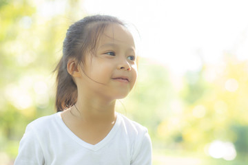 Portrait face of cute asian little girl and child happiness and fun in the park in the summer, smile and happy from asia kid and relax in the garden, lifestyle childhood concept.