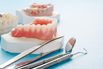 Close up , Complete denture or full denture on blue background. - obrazy, fototapety, plakaty