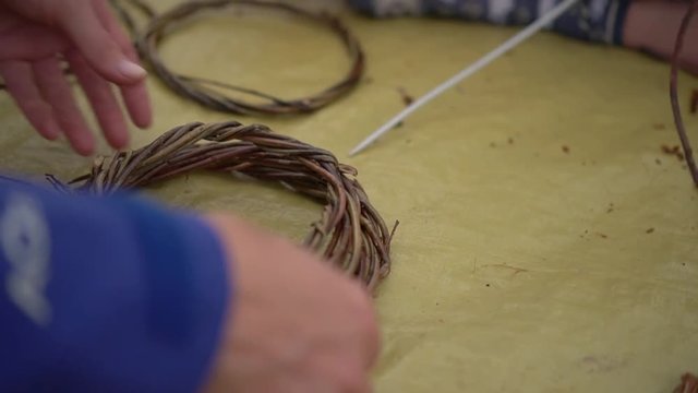 Hands, weaving a basket out of twigs