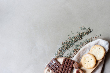 Chocolate, crackers, sugar cane and dried tea leaves with spatula and  filter bags on...