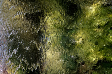 Green ripple on a mirror surface wall 