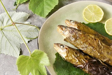 small fish in grape leaves baked as dolma. Mediterranean dish. popular in Greece and Turkey. Fish nawaga baked recipe becomes juicy. usually cooked like mackerel and other small fish.