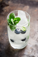 Blueberry mojito cocktail on the wooden background. Selective focus. Shallow depth of field.