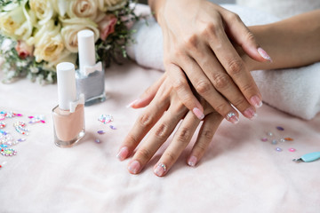 Obraz na płótnie Canvas Beautiful manicure nails paint with glitter, gems and varnish in nail salon