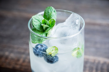 Blueberry mojito cocktail on the wooden background. Selective focus. Shallow depth of field.