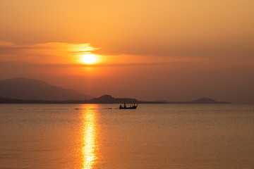 Naklejka na ściany i meble beautiful sky evening atmosphere sunset over sea with fishing boat