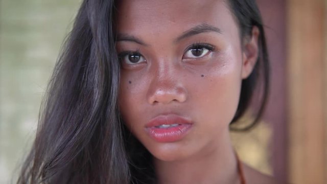 young model with long hair, dark-skinned girl with full lips poses for camera