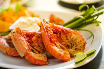 Beautiful orange shrimp cut in half on a plate on the table