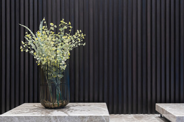 Flowers in black metal wire frame vases on marble table with black straight line wall interior decoration contemporary