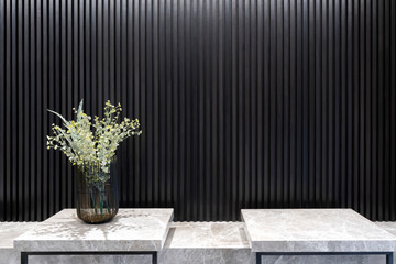 Flowers in black metal wire frame vases on marble table with black straight line wall interior decoration contemporary