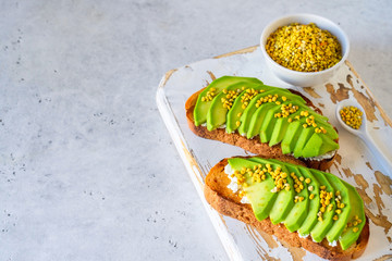 Toasted bread with avocado, ricotta (cream cheese), bee pollen.