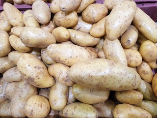 Top view of fresh potatoes as a background in the supermarket for sale, ready to cooking