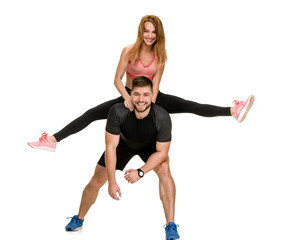 Cheerful sporty people having fun, sportsman piggybacking his girlfriend