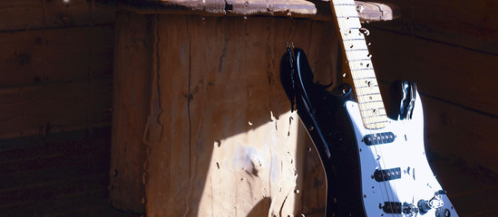 electric guitar on the wooden boards behind the glass with water drops