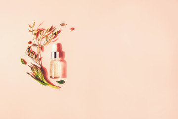 Bottle with natural serum with vitamins on a pink background. Cosmetic procedures for the face