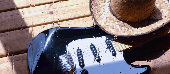 electric guitar on the wooden boards behind the glass with water drops
