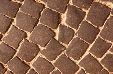 Background of stone surface texture. Old road made of natural stone. Cropped shot, horizontal, plenty of space, close-up. Concept of construction and design.