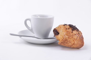 Fresh and tasty puff pastry roll filled with chocolate resting on a cup of coffee