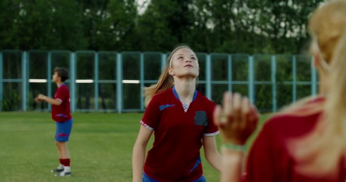 Young Caucasian teenager girl soccer football players heading the ball during practice session. 4K UHD