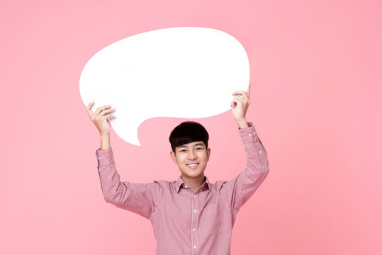 Happy smiling young handsome Asian man holding speech bubble