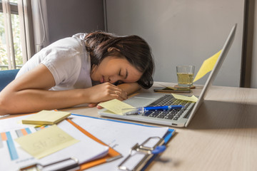 Tired woman working overtime sleeping at workplace