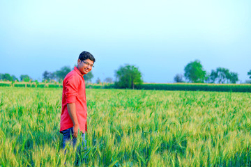 Naklejka na ściany i meble Young indian farmer at field