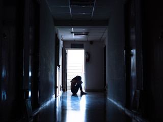 Silhouette of a sad young girl sitting in the darkl, Domestic violence, family problems, Stress, violence, The concept of depression and suicide.