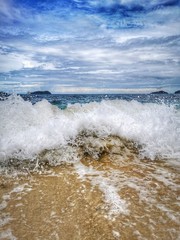 Closeup with the sandy beach splashing water and swash wave in Kota Kinabalu, Tanjung Aru beach. Sabah, Malaysia.