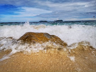 Closeup with the sandy beach splashing water and swash wave in Kota Kinabalu, Tanjung Aru beach. Sabah, Malaysia.